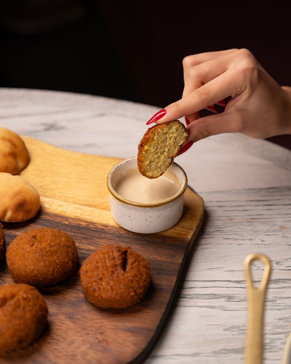 Falafel spezzato intinto nella salsa di tahina