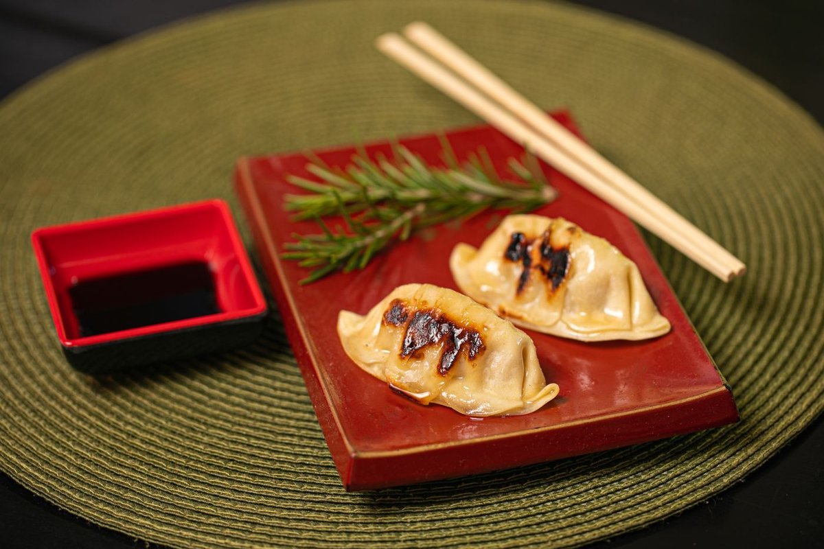 Gyoza dorati sul fondo, ravioli giapponesi con salsa