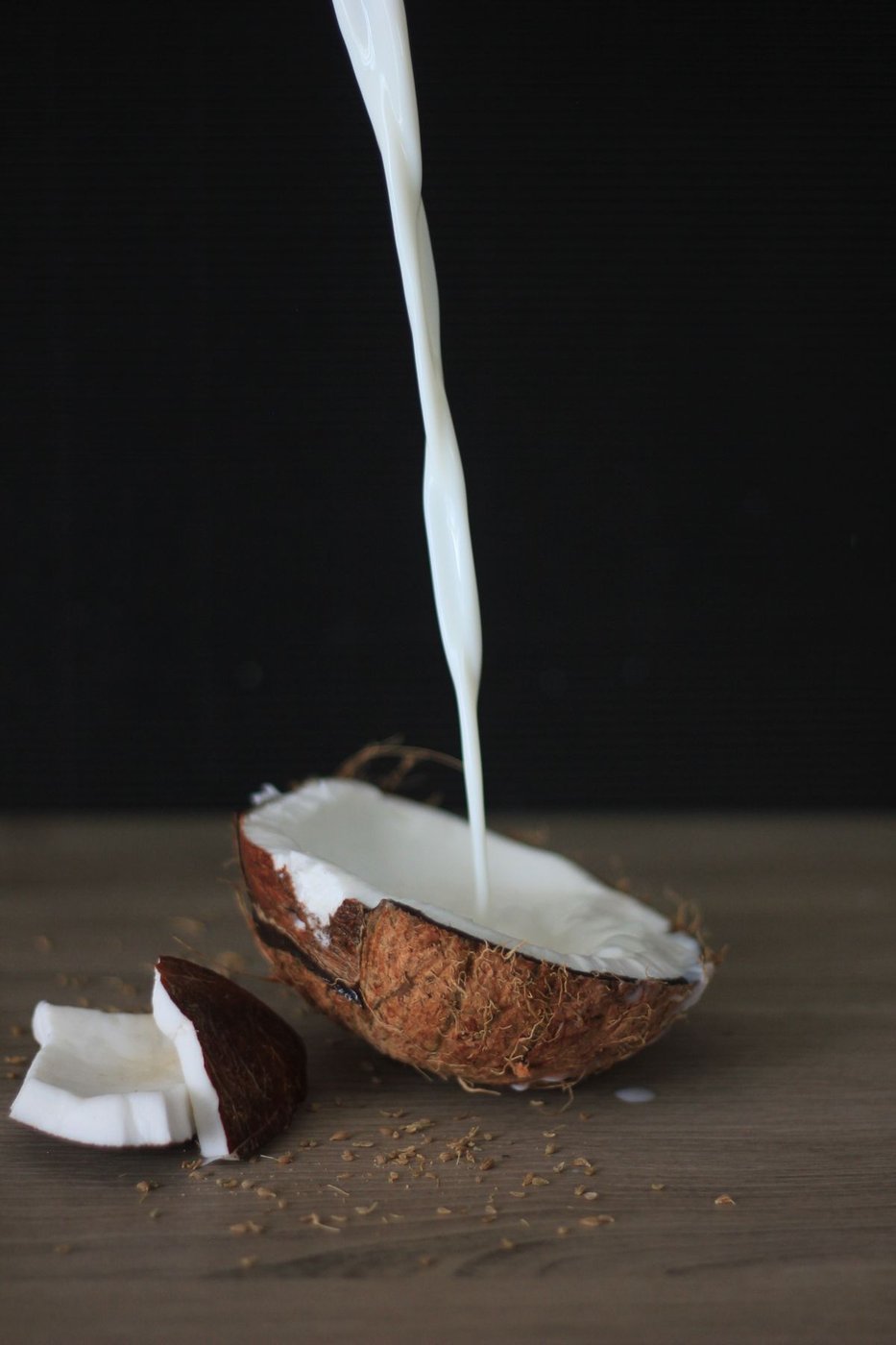 Latte di cocco versato in una noce di cocco