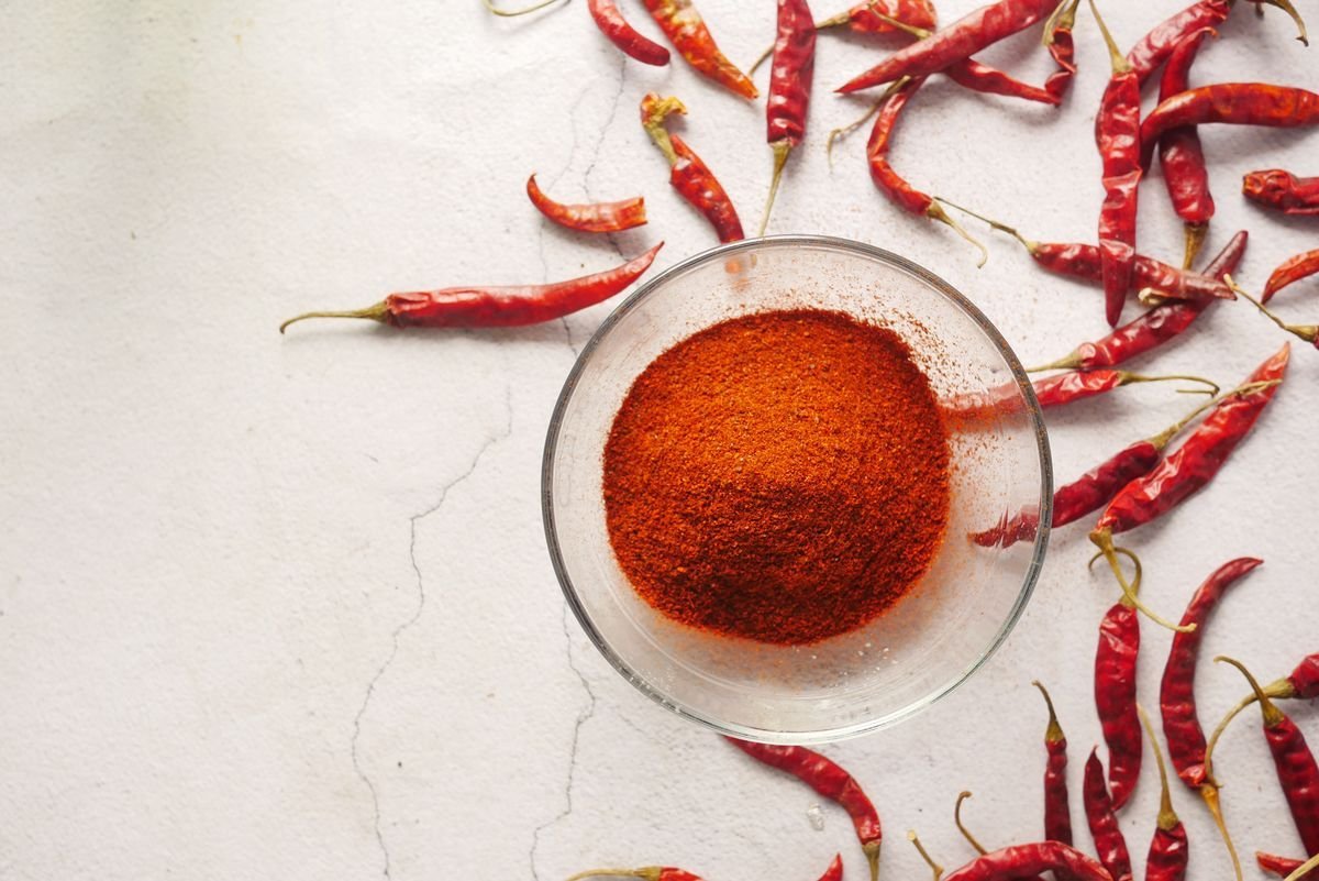 Paprika in polvere in una ciotola con peperoncini secchi